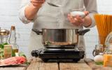 Cocinero añadiendo sal yodada al agua para cocer pasta