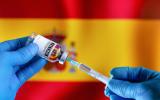 Imagen de vacuna COVID sobre bandera de España