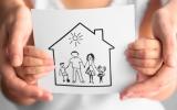 Las manos de un niño mostrando un dibujo de una familia en el hogar