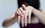 Mujer se toca mano izquierda donde tiene dolor por osteoartritis