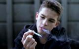 Chico adolescente fumándose un cigarrillo
