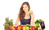Mujer sentada a una mesa con frutas y verduras