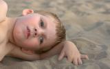 Niño autista tumbado en la playa