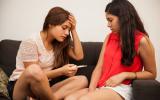 Dos adolescentes observan los resultados de un test de embarazo