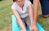 Un terapeuta ayuda a una mujer con artritis a realizar sus ejercicios