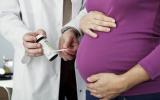 Embarazada junto al doctor con un test de orina