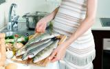 Embarazada preparando pescado para comer