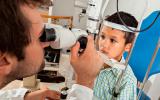 Un oftalmólogo revisa la vista a un niño