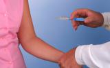 Doctor administrando la vacuna del VPH a una mujer adulta