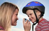 Una mujer ofrece el inhalador a su hijo antes de que esté monte en bicicleta