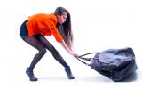 Una mujer se esfuerza en arrastrar un pesado bolso