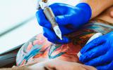 Un profesional realizando un tatuaje de colores
