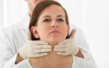 Médico palpando las glándulas tiroideas
