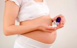 Mujer embarazada con un frasco de antibióticos en las manos