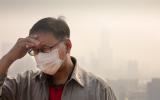 Hombre chino con mascarilla al aire libre con elevados niveles de contaminación atemosférica