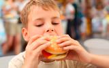 Un niño comiéndose una hamburguesa