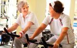 Dos mujeres mayores realizan ejercicio en bicicleta estática
