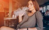 Mujer embarazada fumando con un cigarrillo electrónico