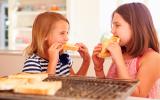 Dos niñas comen pan tostado
