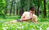 Un joven alérgico se suena la nariz en el campo