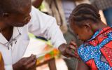Un sanitario vacuna a una niña contra la fiebre amarilla