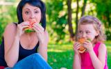 Madre e hija comiendo hamburguesa