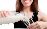 Una mujer vierte leche en un vaso