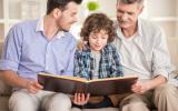 Abuelo, padre e hijo leen juntos un libro