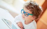 Niño pequeño con gafas mirando una tablet