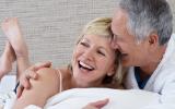 Mujer con menopausia disfrutando de su pareja en la cama