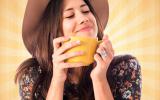Una joven sostiene una taza de té en las manos con gesto satisfecho