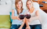 Dos mujeres brindan con sendas copas de vino tinto