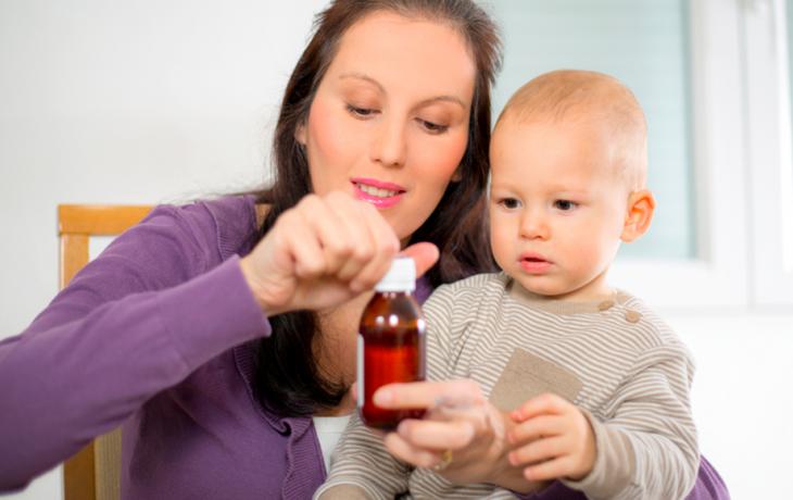 Madre dando ibuprofeno a su hijo