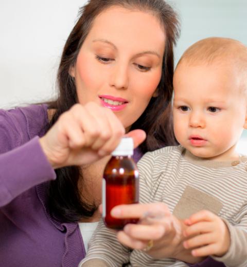 Madre dando ibuprofeno a su hijo