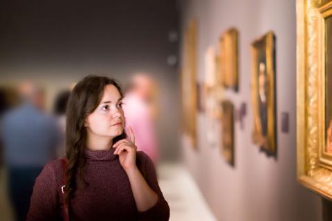 Mujer observando la belleza de un cuadro en el museo
