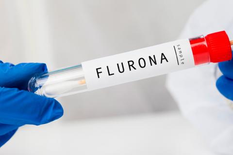 Médico con un tubo de muestra de sangre con resultado positivo para Flurona doble virus Gripe + coro
