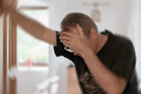 Mareos al levantarse: causas de la hipotensión ortostática Hombre mareándose al levantarse
