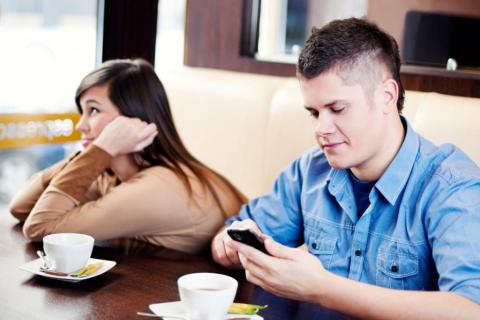 Un joven consulta su &#039;smartphone&#039; mientras su novia se aburre