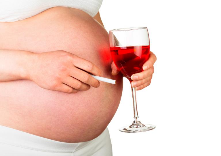 Mujer embarazada fumando y bebiendo alcohol