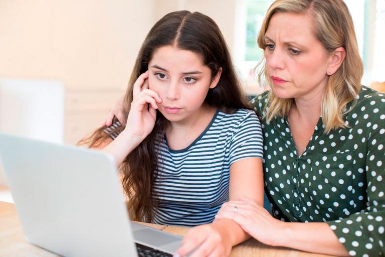 Madre dando consejos a su hija para prevenir el ciberbullying