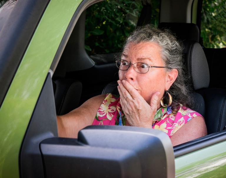 Una mujer mayor conduce con gesto de preocupación