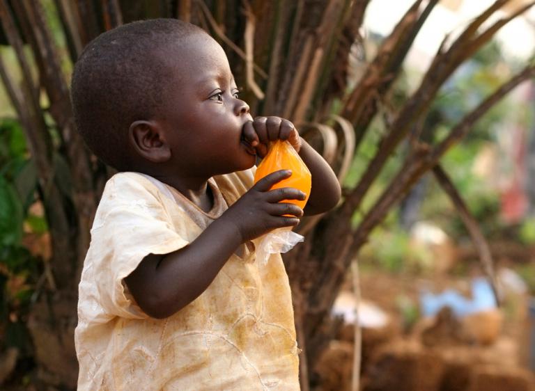 Niño malnutrido africano juega en una zona pobre