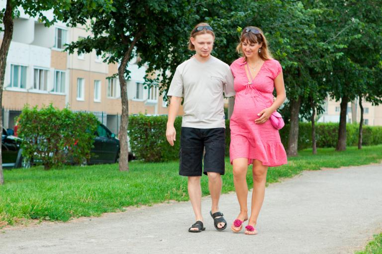 Mujer embarazada paseando junto a su pareja