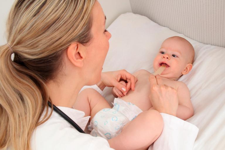 Pediatra mirando la boca a un bebé