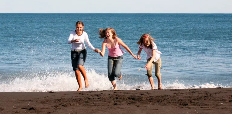Grupo de amigas saliendo del mar cogidas de la mano