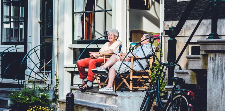 Dos mujeres hablando en la puerta de casa