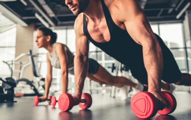 Pareja realizando pesas para mejorar su tono muscular