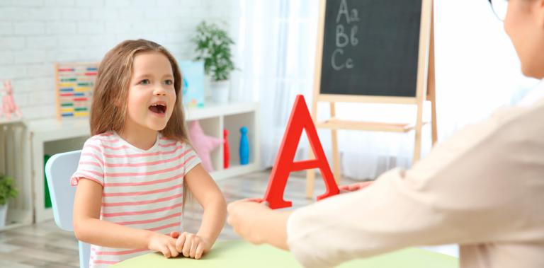Logopeda enseñando a una niña autista