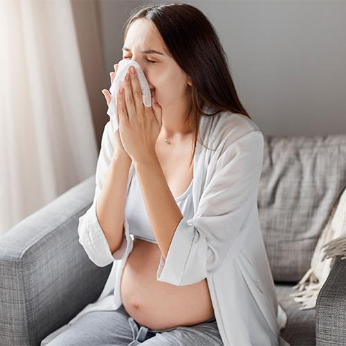 Embarazada con picor nasal por alergia sonándose la nariz