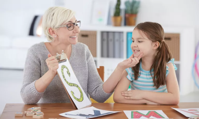 Niña haciendo ejercicios para corregir la dislalia